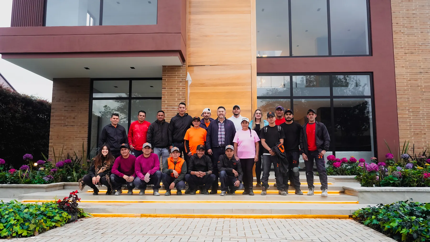 El equipo de Smartinn reunido frente a una casa de ladrillo y madera con ventanales