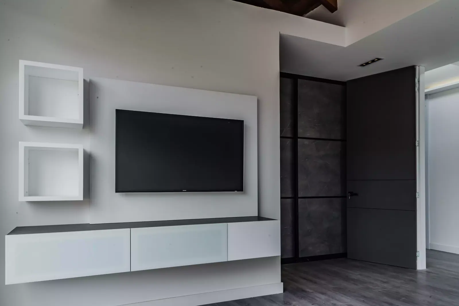 Mueble de televisión flotante blanco con repisas cúbicas y panel de fondo, fabricado a medida