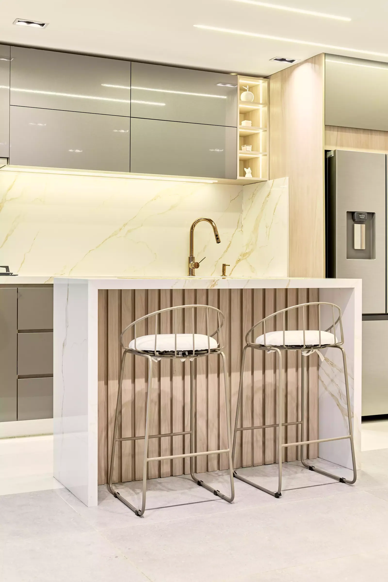 Cocina integral con isla y sillas altas en un apartamento remodelado por Smartinn