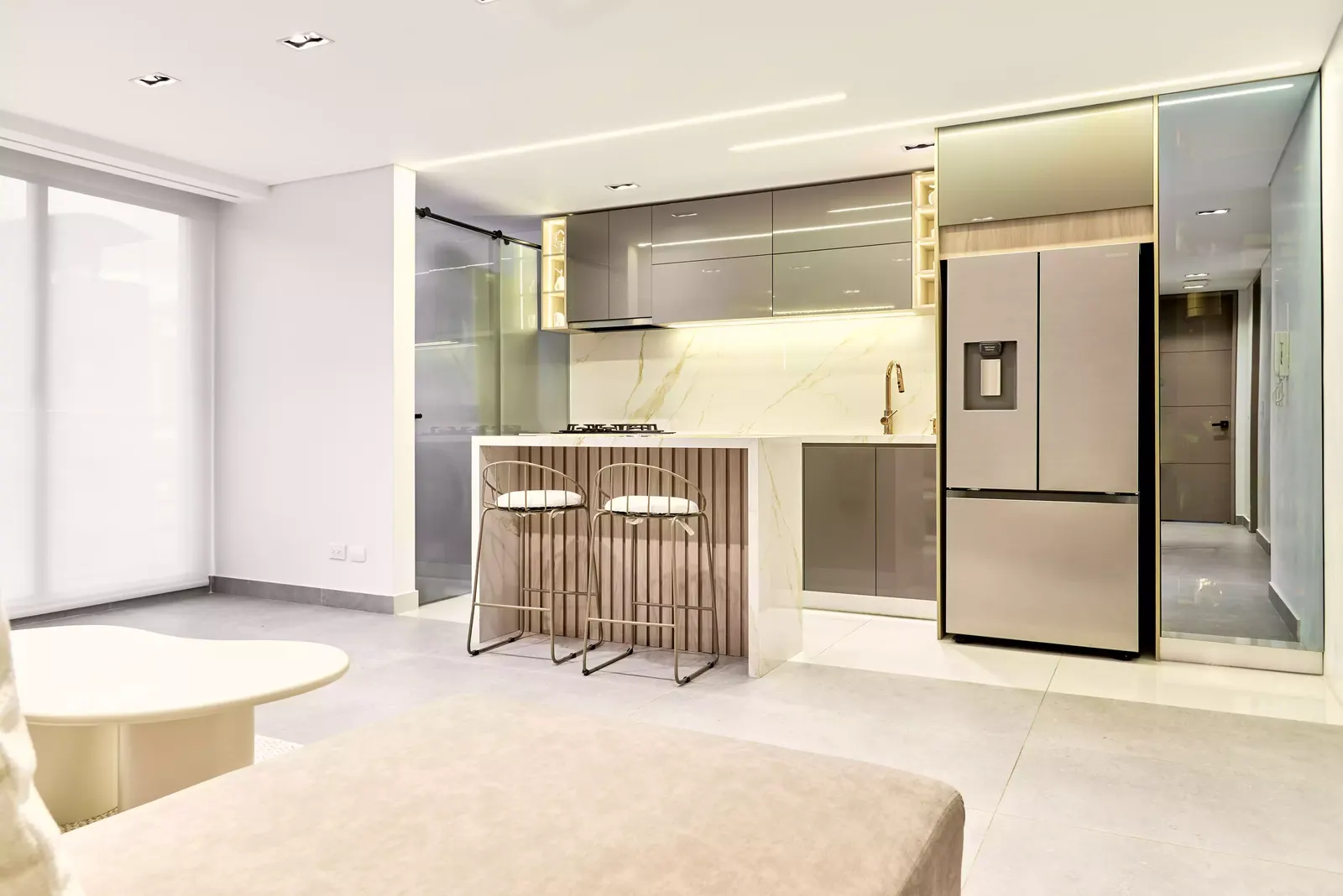 Cocina con isla abierta a la sala y piso claro en un apartamento minimalista