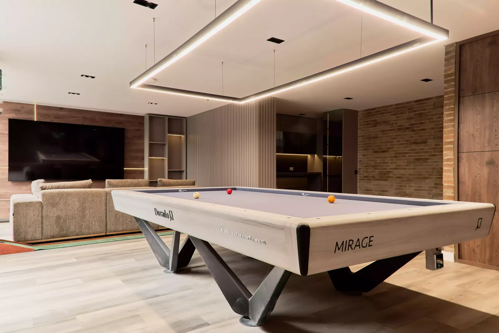 Salón con marco de luz lineal en el cielo raso, mesa de billar y sala con televisión